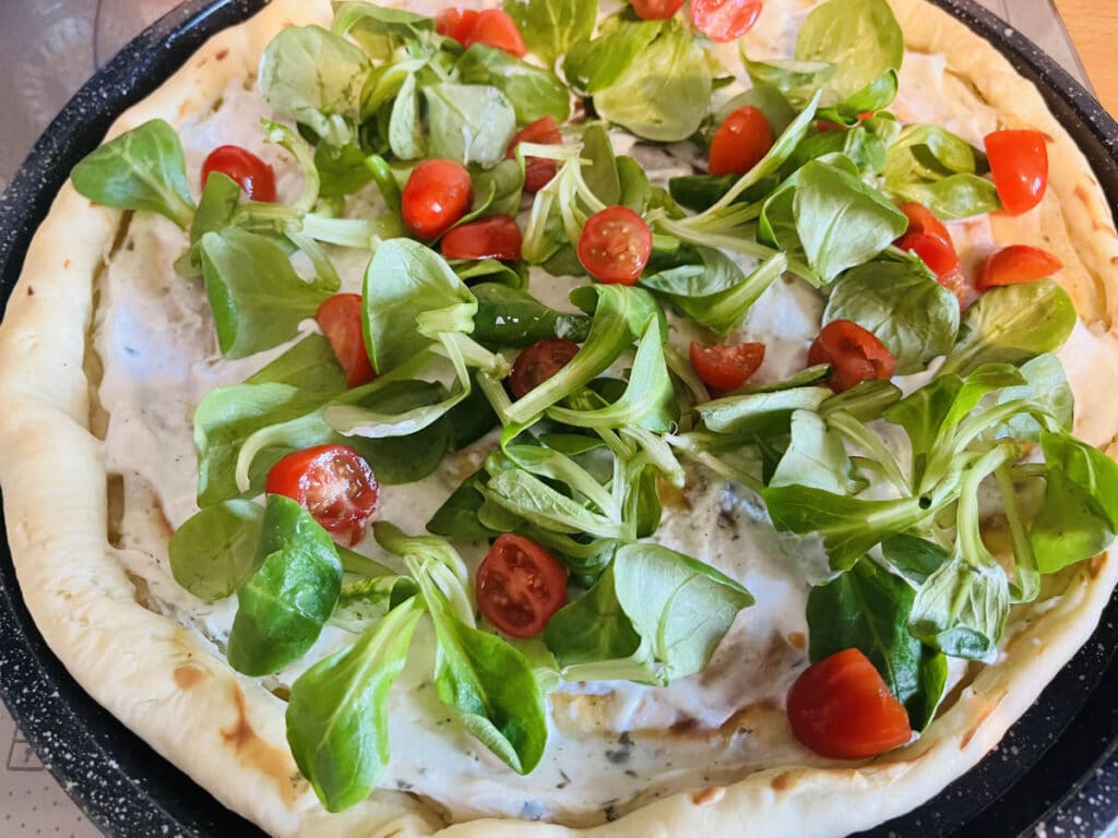 cherry tomatoes and mache on flammkuchen before cooking