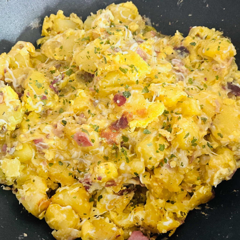 Ham, potato, egg and cheese scramble in the pan