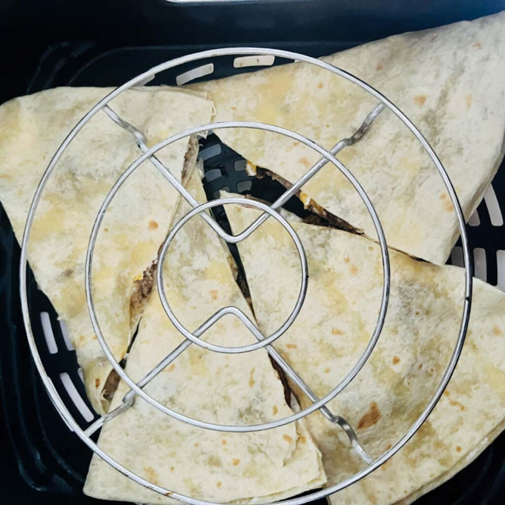 chicken quesadillas in the air fryer basket, with steamer rack on top