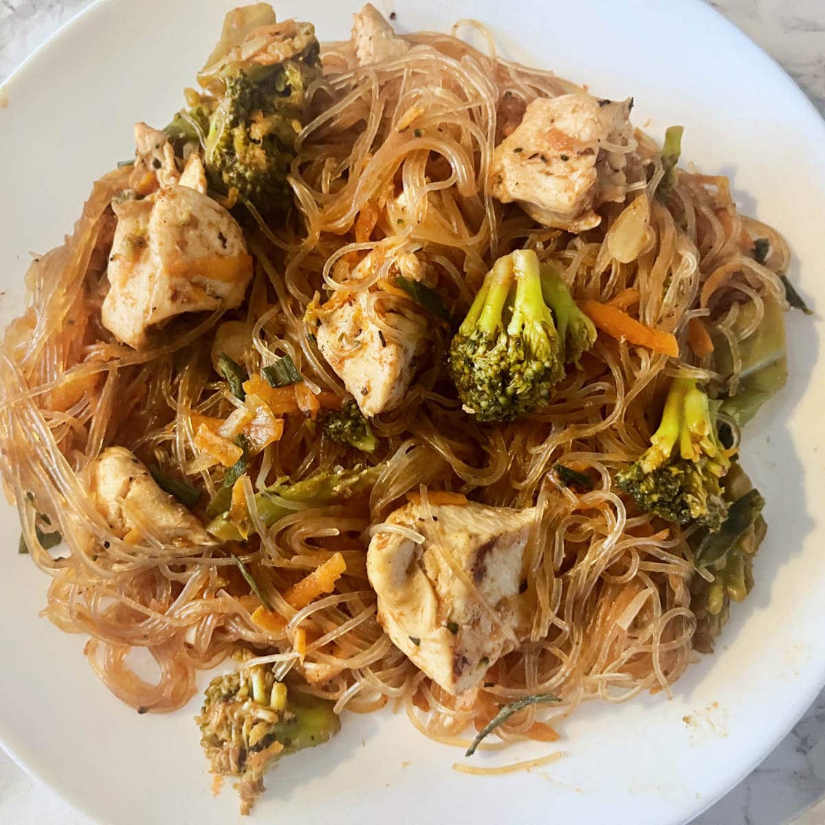 chicken stir fry with rice noodles, broccoli, and carrots