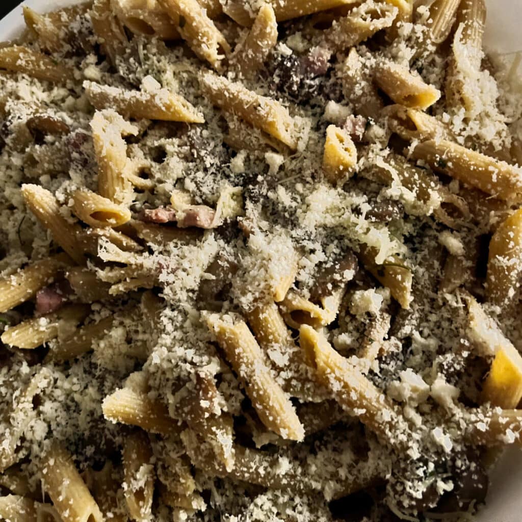 Topping the mushroom casserole with parmesan cheese