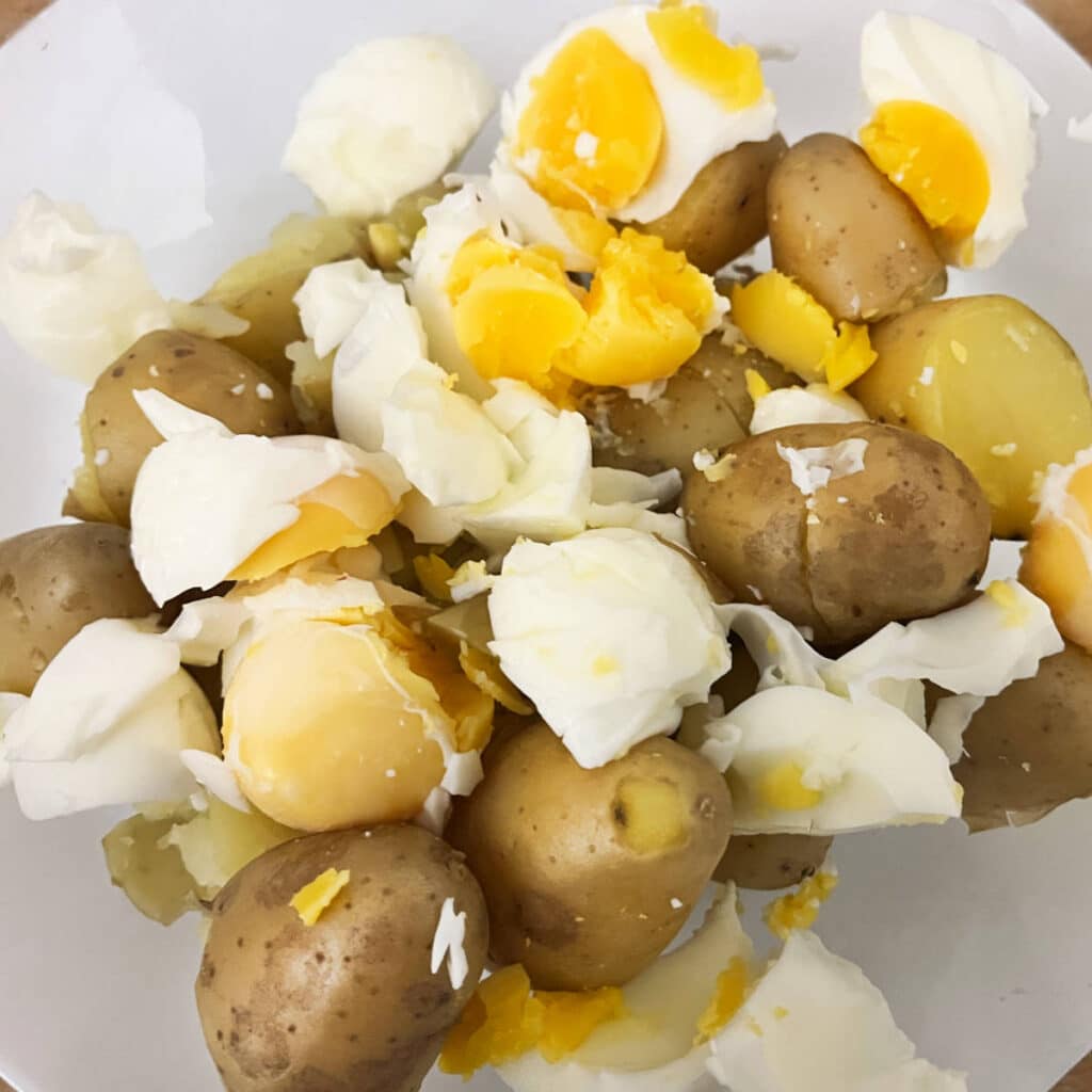 Mixing boiled eggs and boiled potatoes