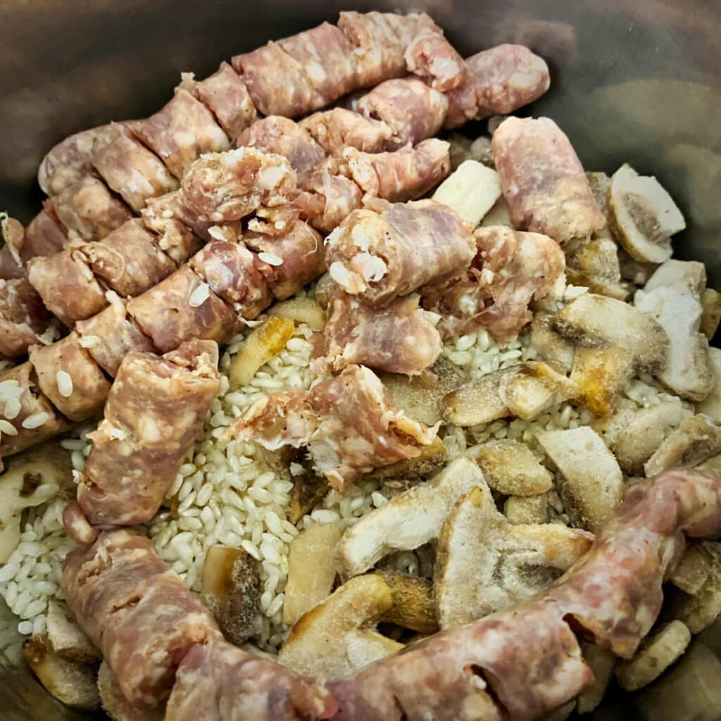 Uncooked sausages, mushrooms and rice, ready for the Instant Pot